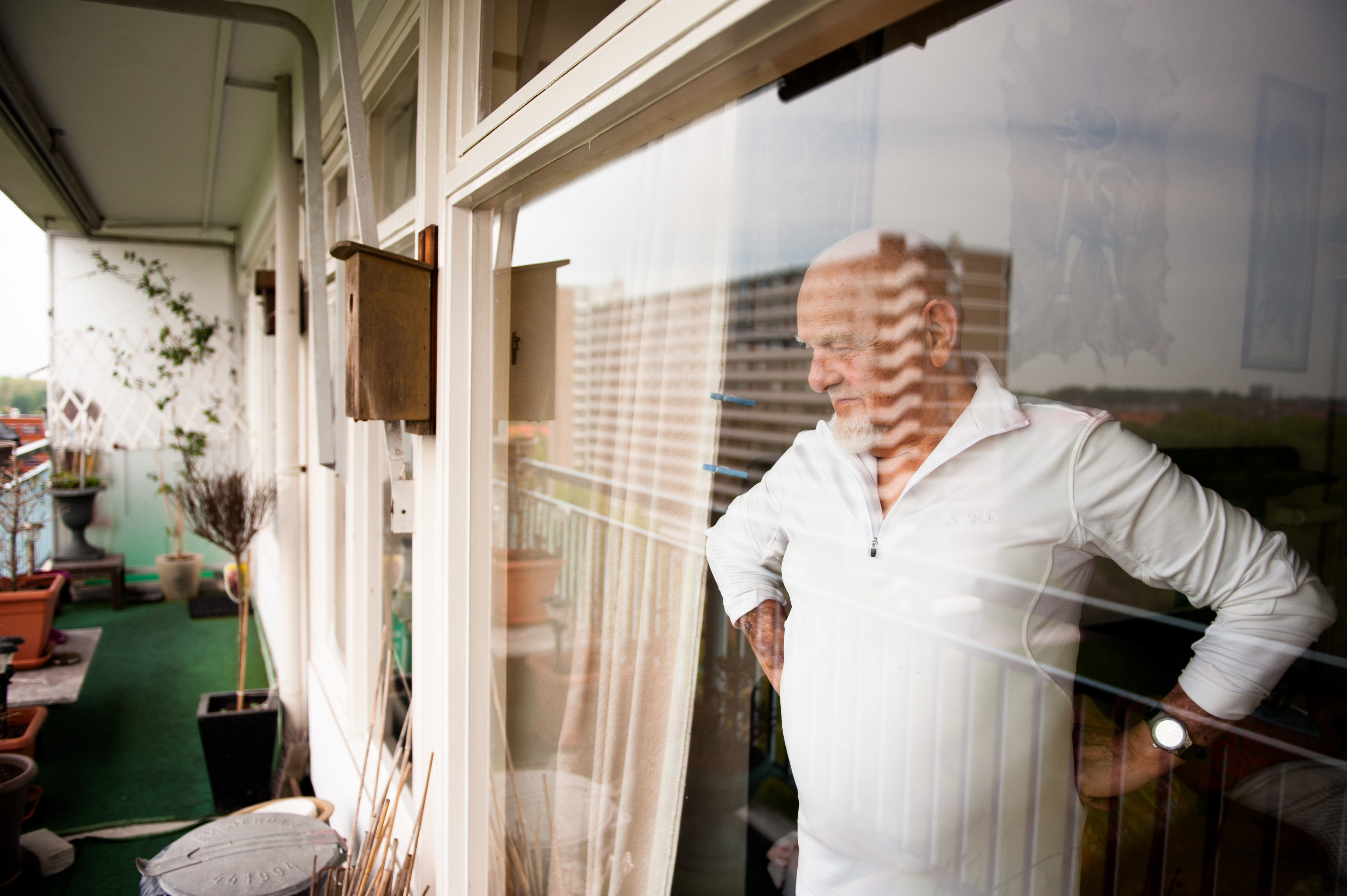 senior se dívá zamyšleně z okna