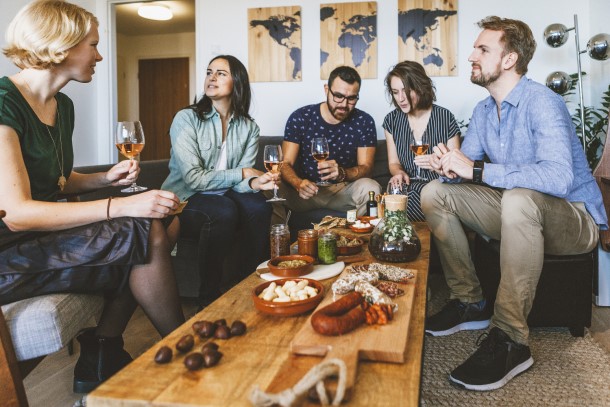 Přátelé spolu popíjejí v obýváku.