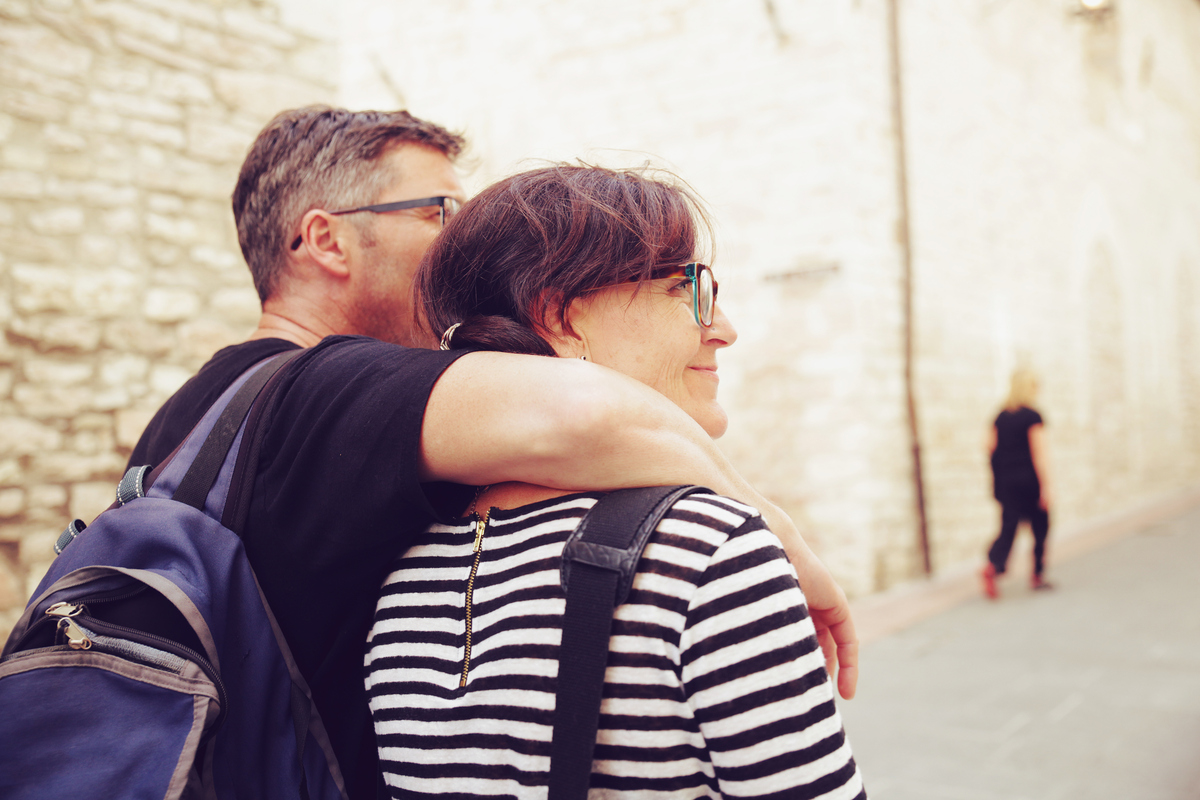 pár ve středních letech na výletě, muž drží ženu kolem ramen