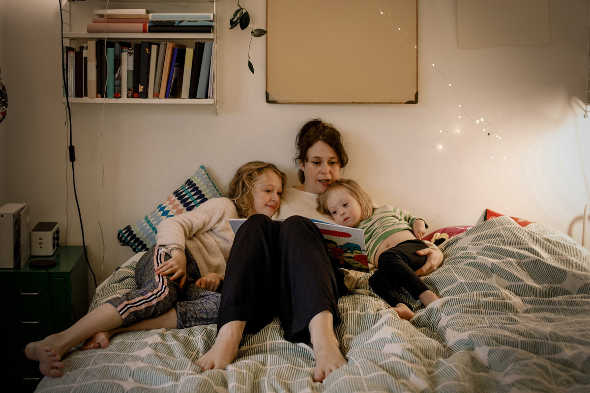 maminka s dětmi čte pohádku před spaním