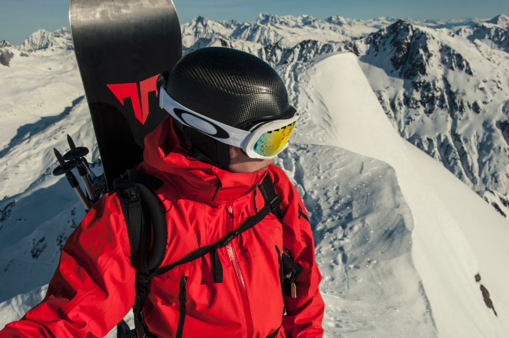 snowboardista nesoucí si prkno na zádech po cestě na zasněžený svah