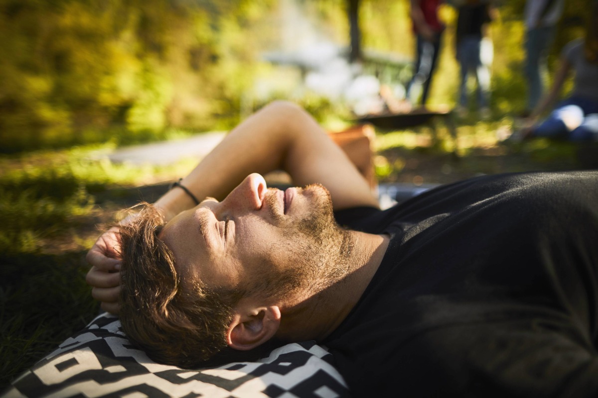 Muž odpočívající na dece jako součást cesty k většímu klidu