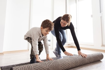 osvc Pojištěná maminka samoživitelka rozbaluje s desetiletým synem koberec