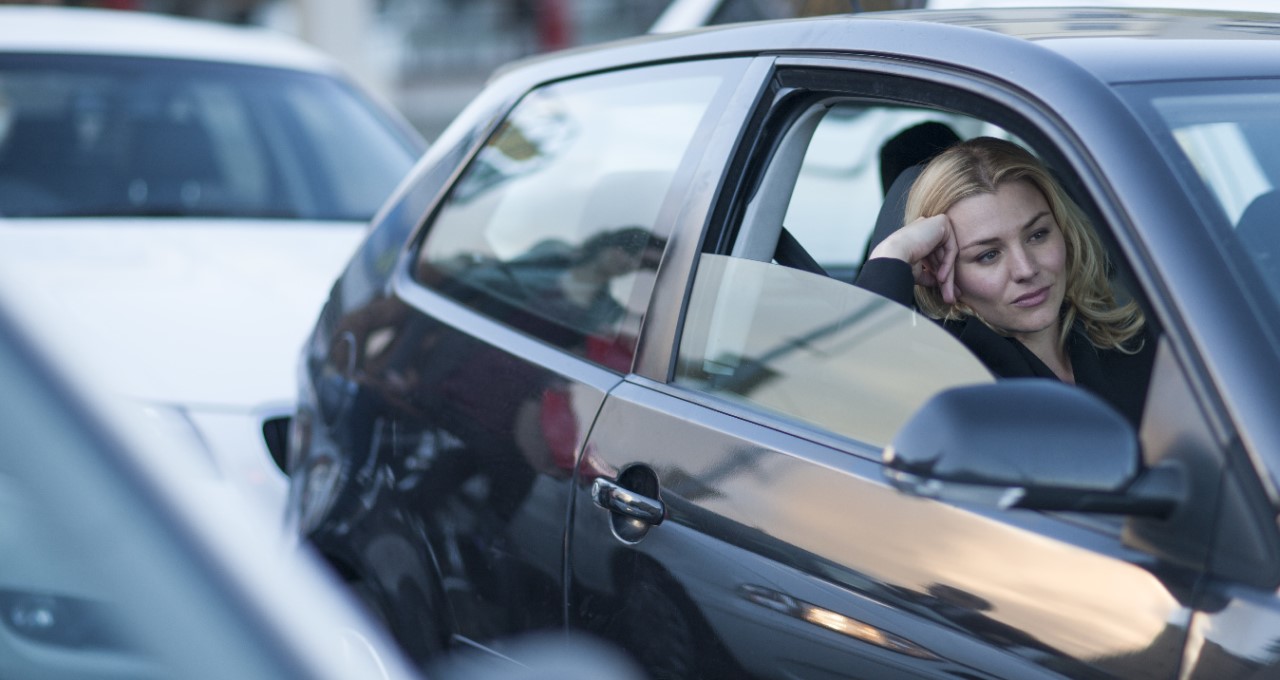 Mladá žena sedí na sedadle spolujezdce, protože po vážné nemoci přišla o schopnost řídit auto.